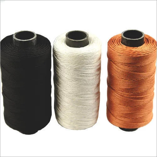Cones of black, white and orange sewing thread